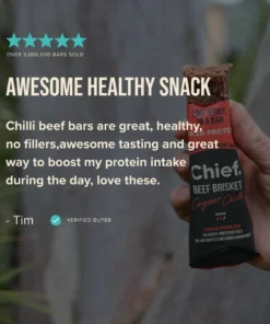 Hand holding a partially eaten Chief Beef Brisket Cayenne Chilli protein bar, labeled with 18.2g protein and certified organic beef.