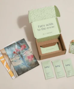 Open cardboard box with "Fatty acids to the rescue" text, three packets labeled "fatty15," a bottle of capsules, and three brochures including one with a dragonfly on the cover