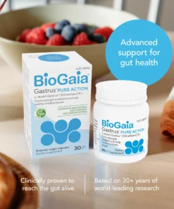 Box and bottle of BioGaia Gastrus Pure Action probiotic vegan capsules on a table with a bowl of berries and bread in the background, with text highlighting advanced gut health support and clinical research credentials.