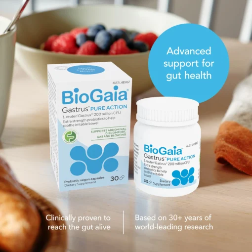 Box and bottle of BioGaia Gastrus Pure Action probiotic vegan capsules on a table with a bowl of berries and bread in the background, with text highlighting advanced gut health support and clinical research credentials.